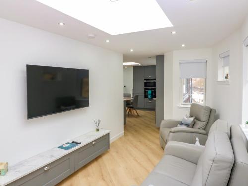 a living room with a flat screen tv on a wall at Craignure in Banff