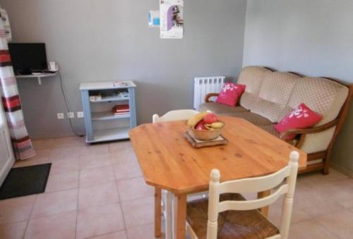 une table de salle à manger avec un bol de fruits dessus dans l'établissement Appartement charmant à Cassen avec parking inclus – 35 m², à Cassen