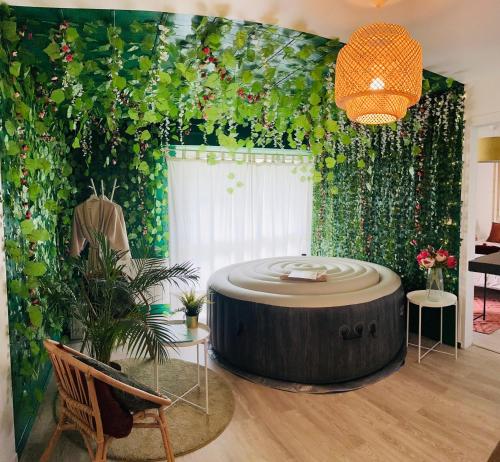 una sala de estar con mesa redonda y plantas en Chez Jade - Spa, Gare et centre ville en Rennes