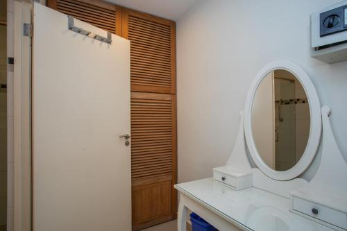 a bathroom with a mirror and a wooden door at Tropical villa Curoyal near the beach in Jan Thiel