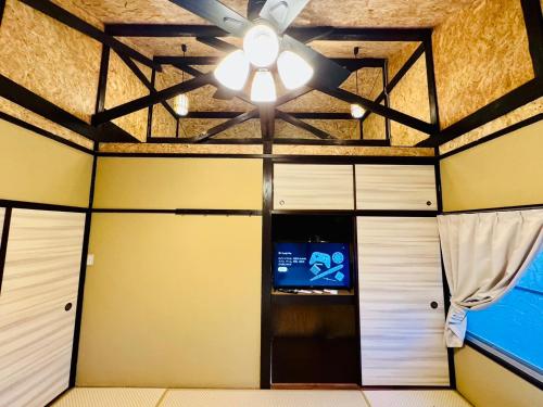 um quarto com uma ventoinha de tecto e uma televisão em 風乃家 Kaze No Ya em Shirahama