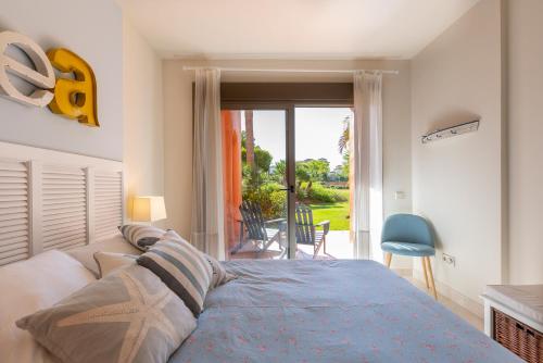 エステポナにあるSailor House con piscina en la nueva Milla de Oroのベッドルーム1室(ベッド1台付)、パティオへのドアが備わります。