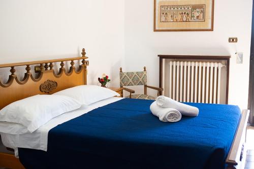 sypialnia z niebieskim łóżkiem i ręcznikami w obiekcie Casa Erzinio w mieście Guarcino