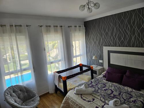 a bedroom with a bed and two windows at Los Pinos Mar y Montaña in Almuñécar