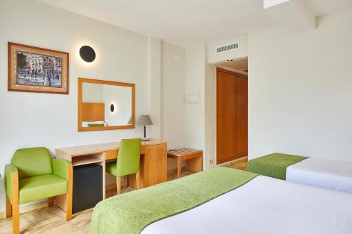 a hotel room with a bed and a desk and a chair at Flor Parks in Barcelona
