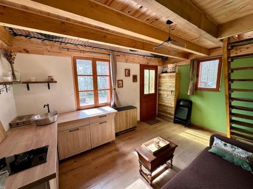 een grote keuken met houten vloeren en groene muren bij Cabane en forêt la mechta in Bologne
