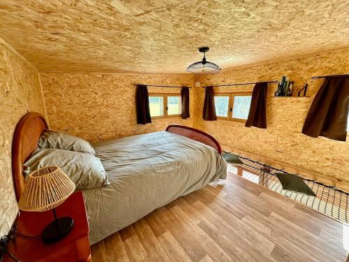 een slaapkamer met een bed in een kamer bij Cabane en forêt la mechta in Bologne