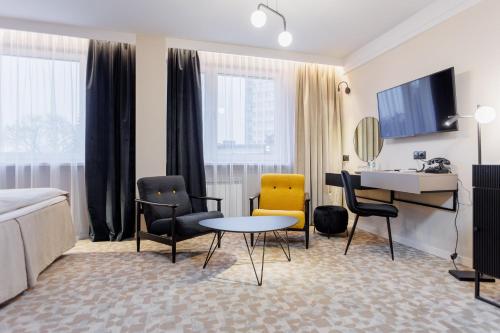 タルヌフにあるホテル ターノヴィアのベッド、テーブル、椅子が備わるホテルルームです。