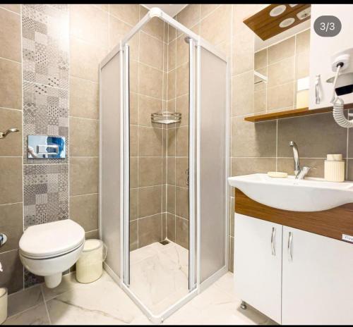 a bathroom with a shower and a toilet and a sink at Körfez Pansiyon in Bodrum City