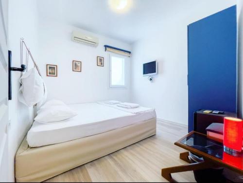 a white room with a bed and a table at Körfez Pansiyon in Bodrum City