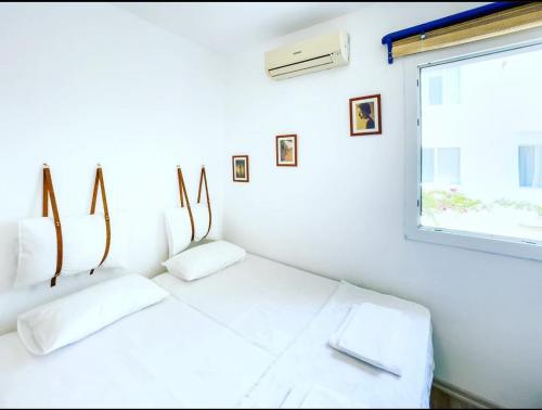 a white room with two white pillows and a window at Körfez Pansiyon in Bodrum City