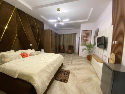 een slaapkamer met een groot bed en een televisie bij Absl Luxury Apartments in Lekki