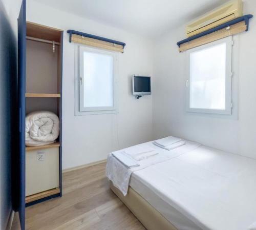 a small bedroom with a bed and a window at Körfez Pansiyon in Bodrum City