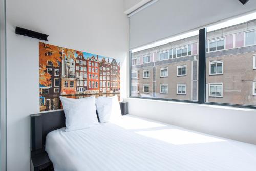 una camera con un letto bianco e una grande finestra di easyHotel Amsterdam City Centre South ad Amsterdam