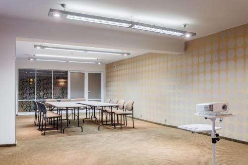 a dining room with tables and chairs and a window at Hotel Tarnovia in Tarnów