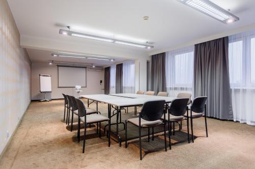 a conference room with a table and chairs and a screen at Hotel Tarnovia in Tarnów