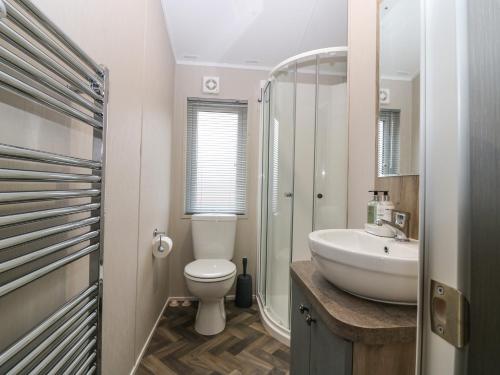 uma casa de banho com um WC e um lavatório em Woodpecker Lodge em Dunbar