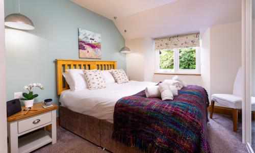 Applethwaite Cottage في Troutbeck: غرفة نوم بسرير كبير ونافذة