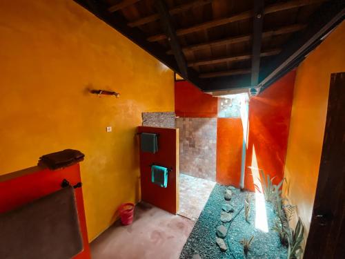 a room with yellow and orange walls and a door at Villa Mitirapa in Tohautu
