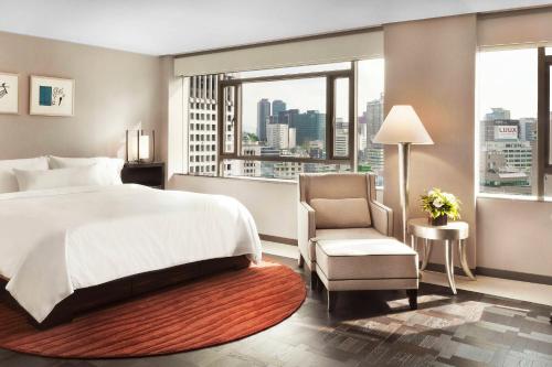 a bedroom with a bed and a chair and a window at Westin Josun Seoul Hotel in Seoul