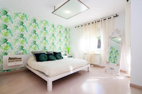 ein Schlafzimmer mit einem weißen Bett mit blauen Kissen in der Unterkunft CABOT in Sant Andreu de Llavaneres