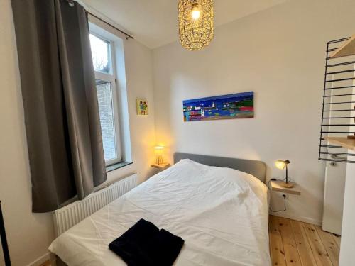 - une chambre avec un lit blanc et une fenêtre dans l'établissement Le cocon de Léonard - Bueren, Curtius, Meuse, à Liège