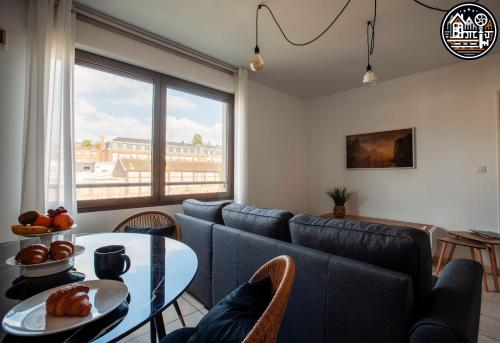 a living room with a blue couch and a table at rouen gare logement avec parking in Rouen