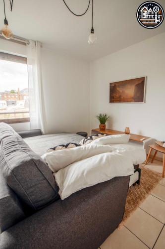 - un salon avec un canapé et des oreillers dans l'établissement rouen gare logement avec parking, à Rouen