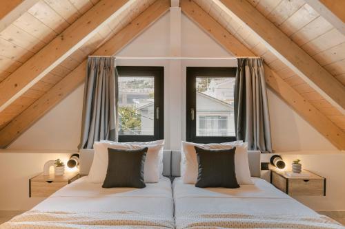 a bedroom with two beds and two windows at Kefalonia Luxury Maisonette in Argostoli