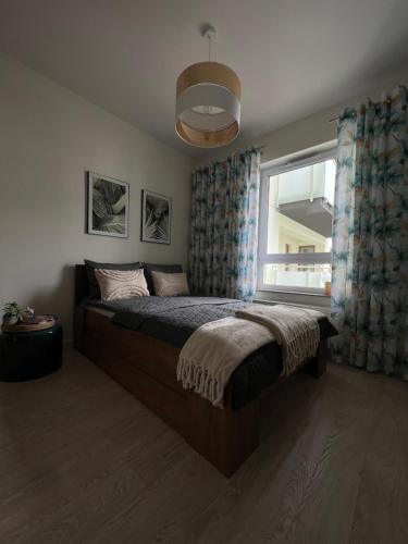 a bedroom with a large bed and a window at Apartament Pileckiego 7b/15 in Suwałki