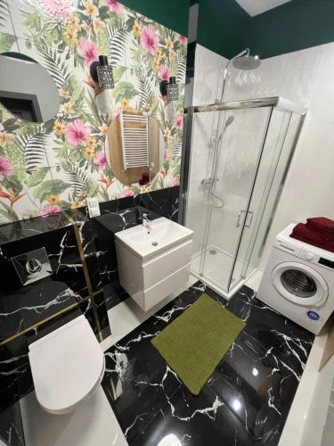 a bathroom with a toilet sink and a shower at Apartament Pileckiego 7b/15 in Suwałki