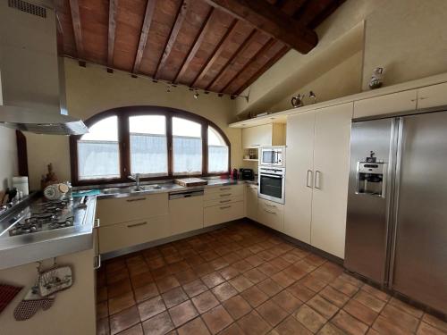 a kitchen with white cabinets and a large window at La Corte di Ronzano in Scarperia