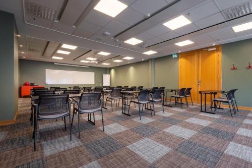 a room with tables and chairs in a classroom at Solna Park & Hotel in Solna
