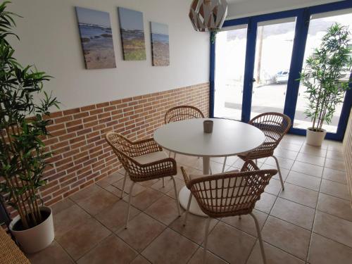 una mesa y sillas en una habitación con una pared de ladrillo en Apartamento La Condesa, en Orzola