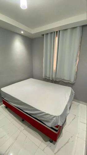 - un petit lit dans une chambre avec fenêtre dans l'établissement Apartamento 100% mobiliado, próximo ao centro da cidade, à Feira de Santana