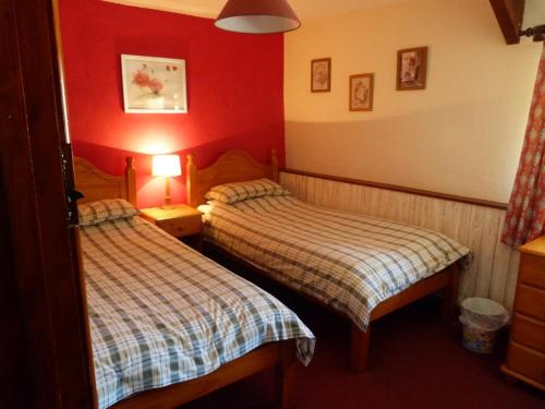 - 2 lits dans une chambre d'hôtel aux murs rouges dans l'établissement Fern Cottage, Triscombe Farm Cottages, à Wheddon Cross