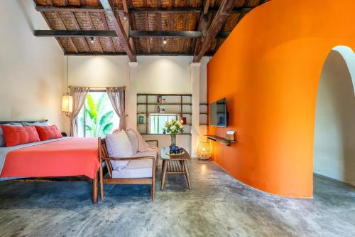 a bedroom with a bed and an orange wall at Garden of Love Villa in An Bang, Hoi An in An Bang