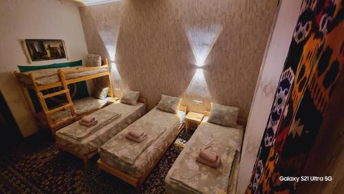 a small room with two beds and a window at Naqqosh in Khiva