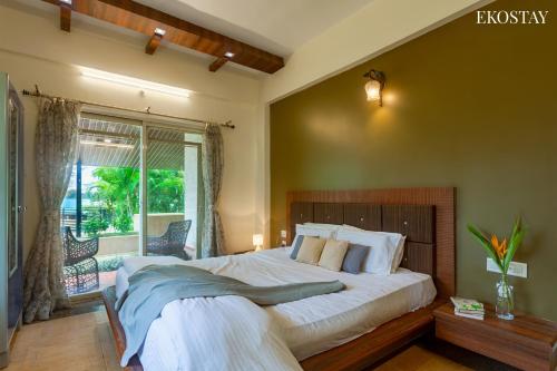 Un dormitorio con una cama grande y una ventana en EKOSTAY GOLD - Windsor Villa, en Panchgani