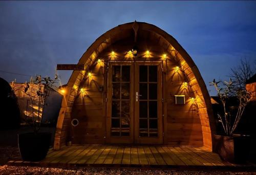 ein Torbogen zu einem Hobbyhaus mit Lichtern in der Unterkunft Les Chalets du Parc 
