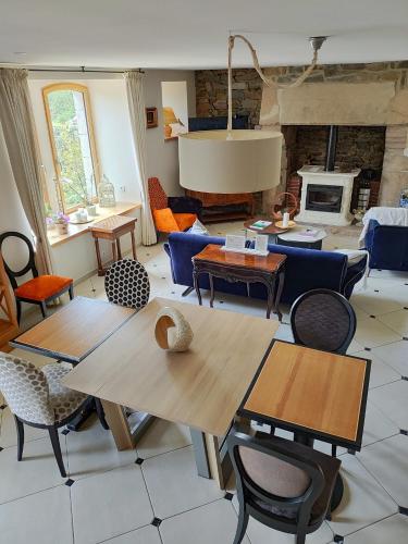- un salon avec des tables, des chaises et une cheminée dans l'établissement Demeure du Porzou, chambres d'hôtes de charme dans demeure d'exception, parc paysager, spa, massages, proche Paimpol, classé 4 épis, à Yvias