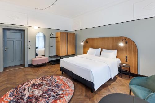 - une chambre avec un grand lit blanc et un canapé dans l'établissement Hotel Astoria Wien, à Vienne