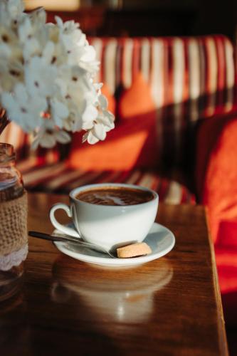 a cup of coffee and a cookie on a table at Celtic Ross Hotel & Leisure Centre in Rosscarbery