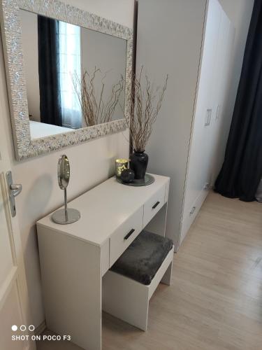 a white dressing table with a mirror on a wall at Apartment Milevoj in Koromačno