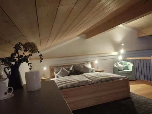 DietramszellにあるMoarhof Ferienwohnung2の木製の天井と大きなベッドのある寝室