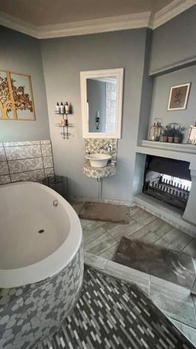 a bathroom with a large tub and a sink at Dullies Dolce in Dullstroom