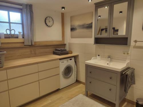 een badkamer met een wasmachine en een wastafel bij Moarhof Ferienwohnung2 in Dietramszell