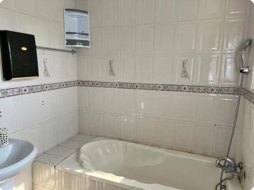 a white bathroom with a tub and a sink at Bambi Smart Homes in Otinshi