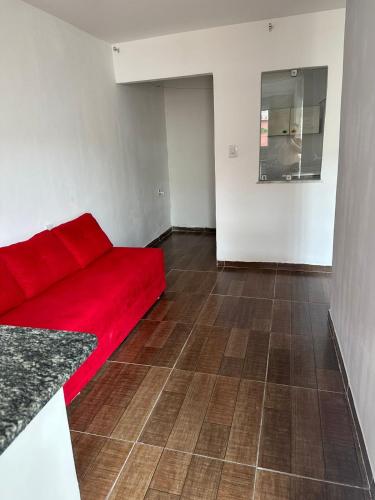 伊塔卡雷的住宿－KITNET - ITACARÉ - BAHIA (DIÁRIAS)，铺有瓷砖地板的客房内的红色沙发