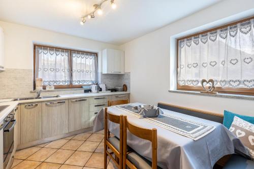 a kitchen with a table and chairs in a room at Villa Maria Moena in Moena